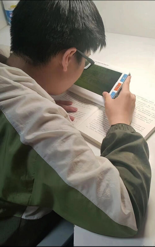 刘明硕今年上初三，他是先天性黑朦，双眼视力只有0.02-0.04，需要使用助视器，才能清文字。 (2).jpg